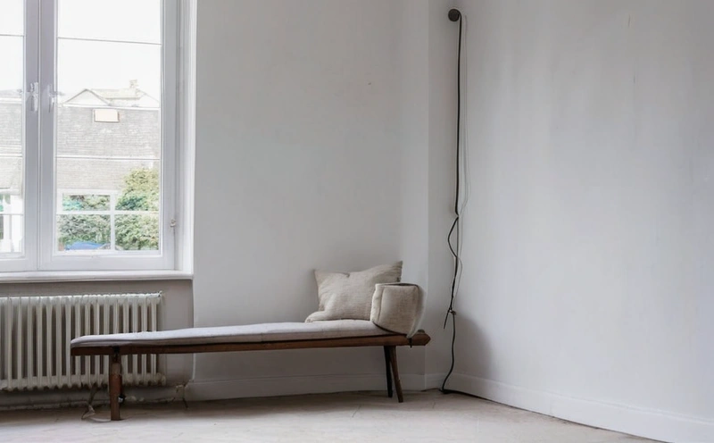 Three pane sash window under a white overcast sky, throwing even light across a plaster wall